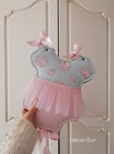 Mavi çiçekli kumaş ve pembe tül detaylı, tulum biçiminde el yapımı bebek albümü
